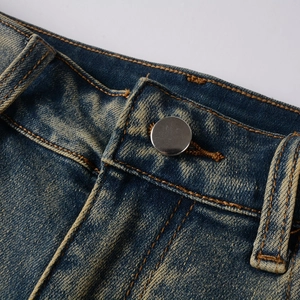 Détail de la taille montrant la texture denim délavé et le bouton métallique argenté