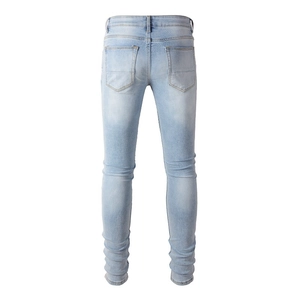 Detail view of light blue slim fit jeans back pockets and washed denim fabric texture