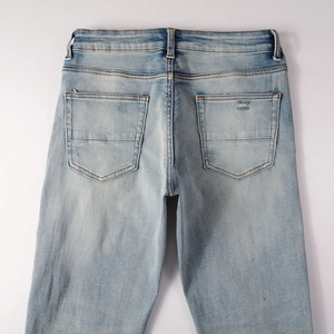 Close-up of light blue distressed denim back pockets with subtle worn detail and stitching