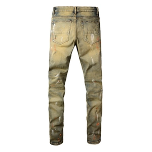 Detail der Herren-Denim-Jeans im Distressed-Look mit Vintage-Waschung und Farbspritzern