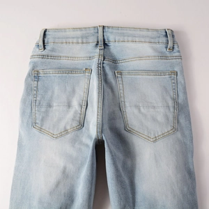 Detail view of light blue denim back pockets with high-quality yellow contrast stitching