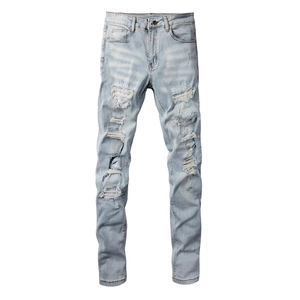 Detailed view of light blue distressed jeans with silver sequin patches and frayed holes