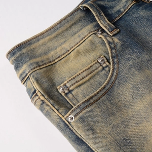 Vue détaillée du denim délavé vintage avec rivets métalliques et surpiqûres jaunes
