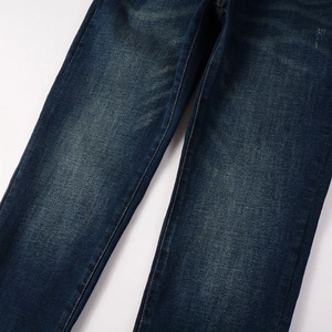 Detailed view of dark blue slim jeans featuring vintage washed fades and whiskers