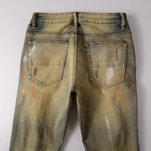 Detailansicht der Rückseite von Vintage-Jeans mit orangen und silbernen Farbspritzern