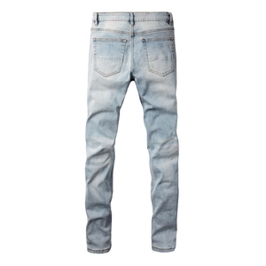 Detailed back view of light blue slim fit denim jeans showing pockets and washed texture