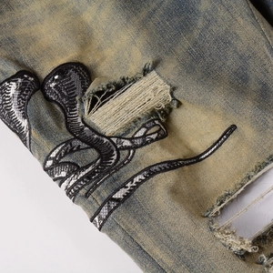 Jean slim homme délavage vintage avec broderie serpent cobra et détails de déchirures usées