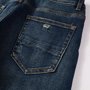 Gros plan sur la poche arrière du jean bleu délavé avec des coutures jaunes vintage