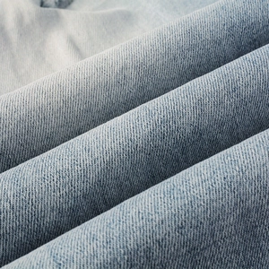 Macro shot of light blue denim fabric texture and cotton twill weave for high street jeans