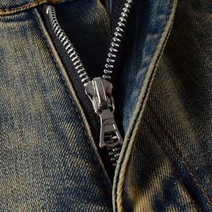 Makroaufnahme von hochwertigem Metallreißverschluss und Vintage-Denim-Textur der Jeans