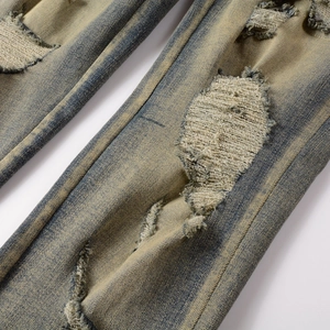 Gros plan détaillé du denim vieilli avec délavage vintage et patchs de réparation brodés