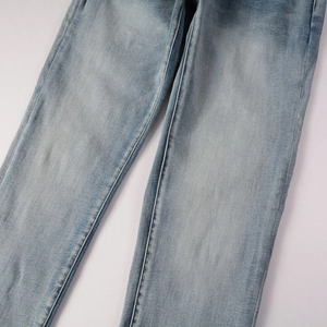 Detail of light blue denim fabric featuring washed finish and reinforced stitching