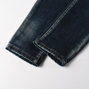 Dettaglio dell'orlo in denim invecchiato con cuciture gialle e finitura lavaggio vintage