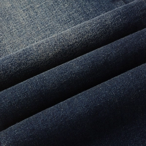 Detailed macro shot of heavy twill dark blue denim fabric with washed texture