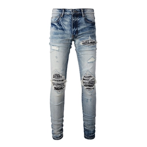 Detail of light blue distressed jeans showing heavy wash and patchwork textures