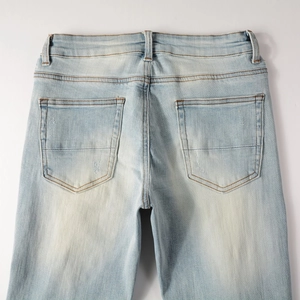 Detailed back view of light blue denim jeans with washed effect and dual pockets