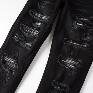 Men's slim fit black distressed jeans with heavy ripped details and street style design
