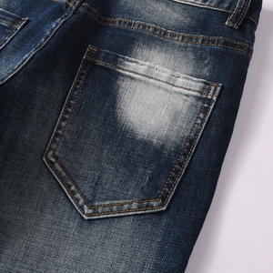 Dettaglio della tasca posteriore dei jeans blu scuro con lavaggio vintage e cuciture