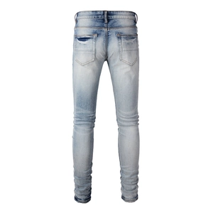 Rear view detail of light blue washed slim fit jeans with distressed texture and pockets