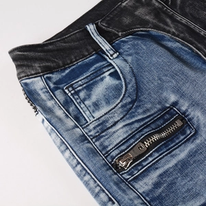 Détail de jean biker high street montrant le tissu patchwork et les poches zippées