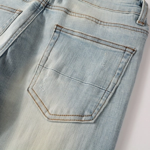 Close-up of slim fit light blue washed denim jeans showing rear pocket stitching and texture
