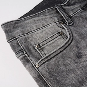 Détails de la taille d'un jean délavé avec rivets métalliques et coutures précises