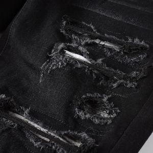 Fashionable men's slim fit black ripped jeans with distressed fabric texture detail