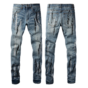 Dettaglio degli schizzi di vernice bianca e nera sui jeans slim fit blu lavaggio medio