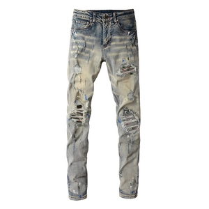 Slim fit men's distressed jeans with blue bleach wash, paint splatters and stripe patches