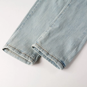 Close-up of light blue slim fit jeans hem with classic orange double stitching