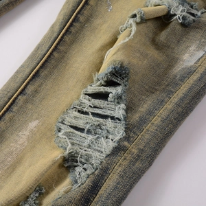 Detailaufnahme von Distressed-Denim mit Vintage-Waschung und rissiger Fransenstruktur
