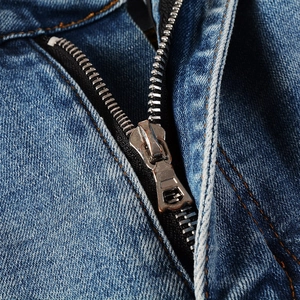 Close-up of premium metal zipper and hardware on distressed American style graffiti jeans