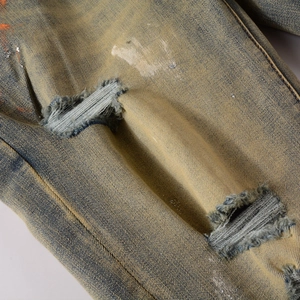 Details von Distressed-Jeans in Blau mit Vintage-Waschung und Farbspritzern