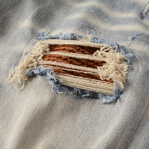 Jean slim pour homme bleu clair avec déchirures stylisées et empiècements matelassés marron
