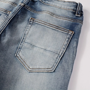 Detail of light blue denim jeans showing back pocket stitching and stonewashed texture