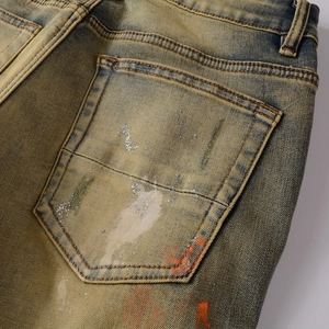 Detail der verwitterten Jeans-Gesäßtasche mit Vintage-Waschung und weißem Farbspritzer