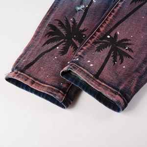 Close-up of purple washed denim jeans with palm tree prints and distressed hole detail