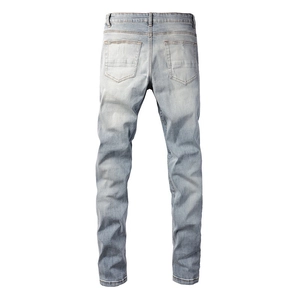 Rear view of light blue washed slim fit jeans with distressed vintage details on pockets