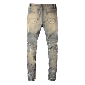 Back view of slim fit distressed denim jeans with paint splatters and vintage wash