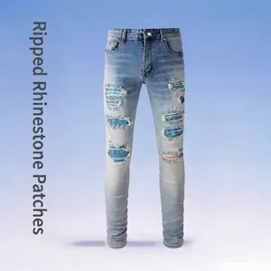 Men's slim-fit light blue distressed jeans with rhinestone patches and ripped details