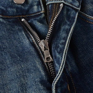 Macro shot of men's blue jeans featuring metal zipper, button and denim texture
