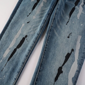 Dettaglio del denim blu con un motivo unico di schizzi di vernice nera e grigia stile street
