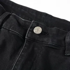 Close-up of black denim jeans waist with silver button and reinforced stitching detail