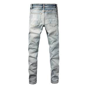 Detail of light blue distressed jeans showing back pockets and heavy wash texture