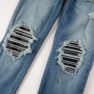 Jean bleu vintage pour homme avec déchirures aux genoux et détails de patchs noirs