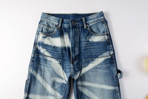 Macro detail of high-waisted denim jeans featuring unique radial bleached wash patterns