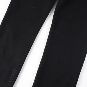 Detailed close-up of black slim fit denim fabric showing fine twill texture and stitching