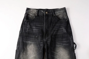 Détail d'un jean gris taille haute avec moustaches délavées et boucles cargo style rétro