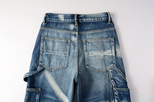 Detail view of washed blue carpenter jeans with large cargo pockets and heavy denim texture