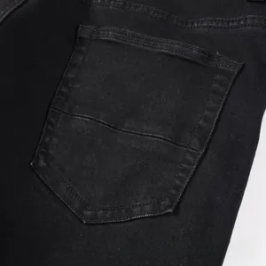 Detailed close-up of the back pocket on slim fit black denim jeans with double stitching